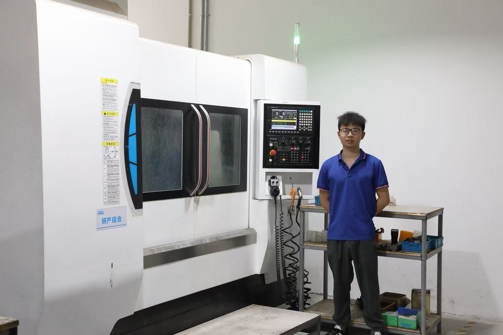 Operator beside a CNC machining center in the Winvera production workshop